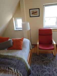 ポラニツァ・ズドルイにあるPiekiełkoのベッドルーム1室(ベッド1台、赤い椅子付)
