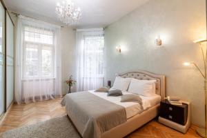 リヴィウにあるAlfa Apartments Levytskohoのベッドルーム1室(ベッド1台、窓2つ、シャンデリア付)