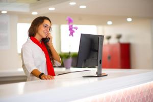 
a woman sitting at a desk in front of a laptop computer at Olé Tropical Tenerife in Playa de las Americas
