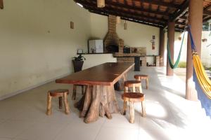 una mesa de madera y taburetes en una habitación en Pousada Ubajara, en Ubajara