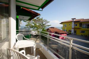 Un balcón con sillas y vistas al océano. en Pousada Canto das Pedras, en Bombinhas