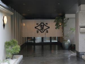un cartello sul lato di un edificio con un cartello sopra di Hot Spring Inn Hakone Suisen a Hakone