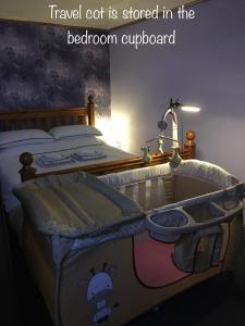 een slaapkamer met een bed met een wieg en een babybedje bij Otley town centre apartment in Otley