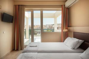 a bedroom with a bed and a large window at Esperia in Thessaloniki