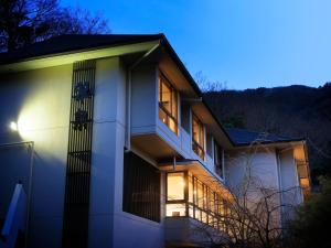 a white house with a balcony at night at Hot Spring Inn Hakone Suisen in Hakone