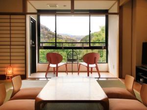 箱根町にある自家源泉かけ流しの宿　箱根翠泉のリビングルーム(椅子2脚、テーブル付)、大きな窓が備わります。