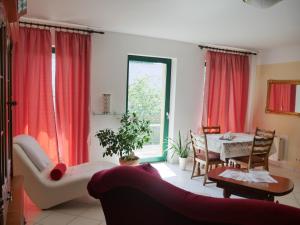 ein Wohnzimmer mit roten Vorhängen und einem Tisch in der Unterkunft Ferienzimmer Weltenbummler,Rheinsberg in Rheinsberg