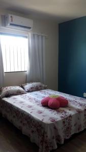um quarto com uma cama com almofadas cor-de-rosa em CASA TEMPORADA SÃO JOSE DA COROA GRANDE - PE em São José da Coroa Grande