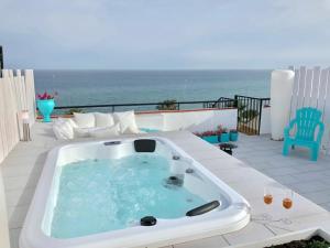 wanna z hydromasażem na patio z widokiem na ocean w obiekcie Beachfront Penthouse - Heated Jacuzzi, BBQ & Bikes w Maladze