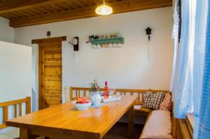uma sala de jantar com uma mesa de madeira e um sofá em CHALUPA NA MLÝNĚ em Přítluky