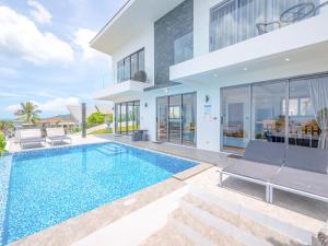 a villa with a swimming pool and a house at Villas Reef View Garden in Koh Samui