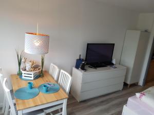 a living room with a table and a tv at Südanker - a58933 in Fehmarn