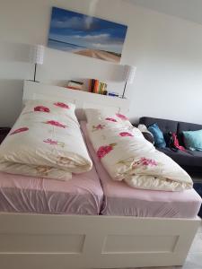 a white bed with two pillows on top of it at Südanker - a58933 in Fehmarn