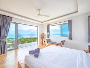 a bedroom with a bed and a large window at Villas Reef View Garden in Koh Samui +23 photos