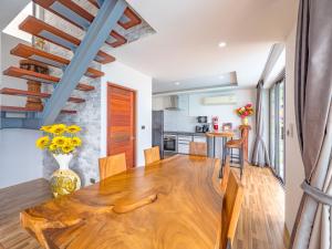 a kitchen and dining room with a wooden table and chairs at Villas Reef View Garden in Koh Samui