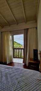 a bedroom with a bed and a large window at Casa Rio - 04 Quartos de Frente para o Mar in Guarda do Embaú +81 photos