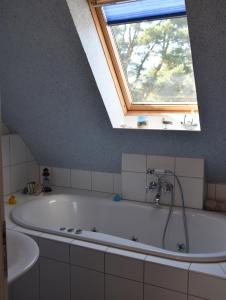 a bath tub in a bathroom with a window at "Ostseefische" in Gutglück