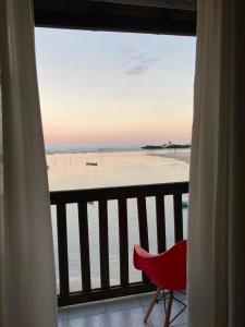 a room with a view of the beach from a balcony at Casa Rio - 04 Quartos de Frente para o Mar in Guarda do Embaú