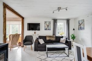 uma sala de estar com um sofá e uma televisão em Spacious and newly renovated farmhouse with indoor pool em Knäred