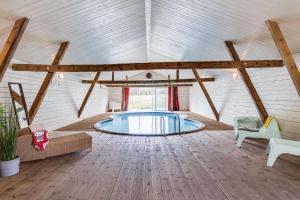 um quarto amplo com uma piscina num edifício em Spacious and newly renovated farmhouse with indoor pool em Knäred