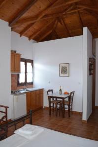 a kitchen and dining room with a table and chairs at Alexandraki Rooms in Poulithra