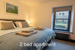 a bedroom with a bed with two towels on it at Market Square Grade II Listed Apartment in Macclesfield