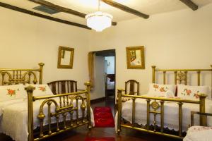 1 dormitorio con 2 camas y lámpara de araña en Hotel Boutique Casa de Hacienda Su Merced, en Puembo