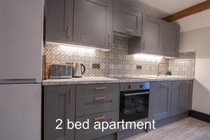 a kitchen with gray cabinets and a counter top at Market Square Grade II Listed Apartment in Macclesfield