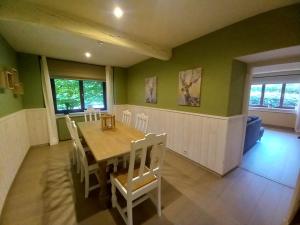 a dining room with a table and chairs at Le jardin des fagnes in Robertville