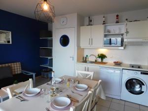 uma cozinha e sala de jantar com uma mesa branca e cadeiras em TY MAGARI em Plougonvelin