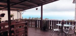 a wooden deck with a table and chairs on a balcony at lilie97418 in La Plaine des Cafres