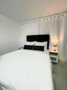 een slaapkamer met een wit bed met witte lakens en kussens bij על הנחל in Bet Sheʼan
