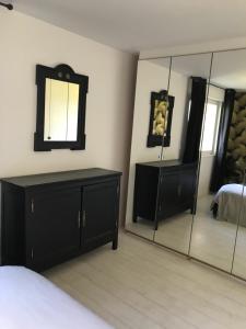 sypialnia z lustrem, komodą i łóżkiem w obiekcie Chambre d'hôte La Clef du Bonheur w mieście Longuenesse