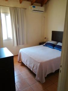 een slaapkamer met een wit bed en een raam bij ANA Apartments & Parking Mendoza in Mendoza +29 foto's