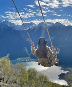 a person on a swing in the mountains at Agriturismo Giacomino in Gera Lario