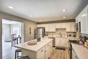 a kitchen with white cabinets and a kitchen island at Stylish and Central Mesa Home with Private Pool! in Mesa