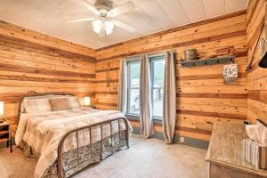 1 dormitorio con paredes de madera, 1 cama y ventana en The Olde Homestead with Fire Pit and Mountain Views!, en Coudersport