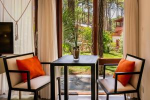 a table and two chairs with a table and a window at Posada La Casona in Mar de las Pampas