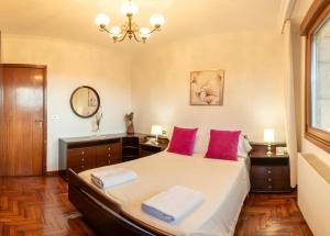 ein Schlafzimmer mit einem großen Bett mit roten Kissen in der Unterkunft Lar de Carmen in Redondela