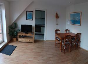 a living room with a dining room table and a television at BUPA02208-Ferienwohnung-Passat in Burg auf Fehmarn