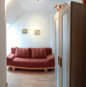 Una sala de estar con un sofá rojo en una habitación. en BUPA02208-Ferienwohnung-Passat, en Burg auf Fehmarn