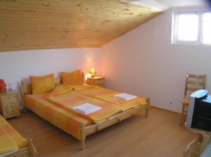 a bedroom with a large bed and a wooden ceiling at Karadzhovy Guest House in Kalofer