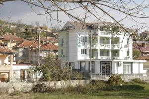 Karadzhovy Guest House في كالوفر: مبنى أبيض عليه علامة خضراء