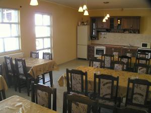 uma cozinha e sala de jantar com mesas e cadeiras em Karadzhovy Guest House em Kalofer