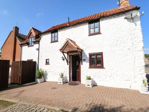 uma casa branca com uma entrada de tijolos em Chalk Cottage em Thetford