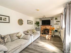 a living room with a couch and a fireplace at Chalk Cottage in Thetford
