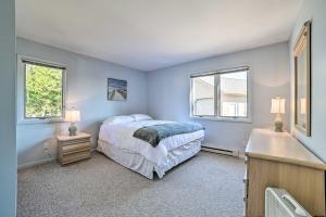een slaapkamer met blauwe muren en een bed en twee ramen bij Lake Huron Home with Direct Beach Access! in De Tour Village