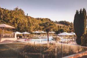 una piscina con sombrillas y un complejo en Relais Almaranto, en Calamandrana