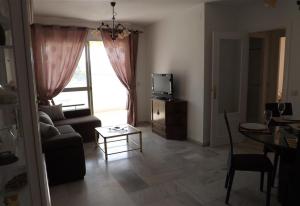 un soggiorno con divano, TV e tavolo di Apartment in Miramar Fuengirola I a Fuengirola