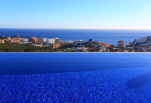 una piscina azul con vistas a la ciudad en Casa Montes Del Castillo, en Almuñécar